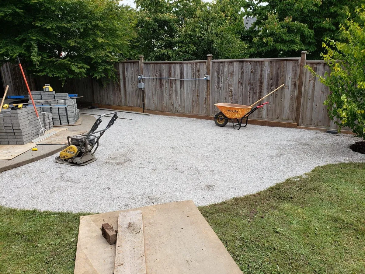 Patio before: compacted gravel base with the plate compactor on site