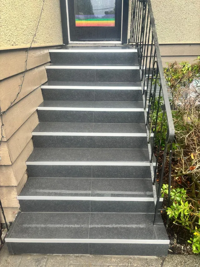 Rebuilt front steps in dark stone with light nosing strips