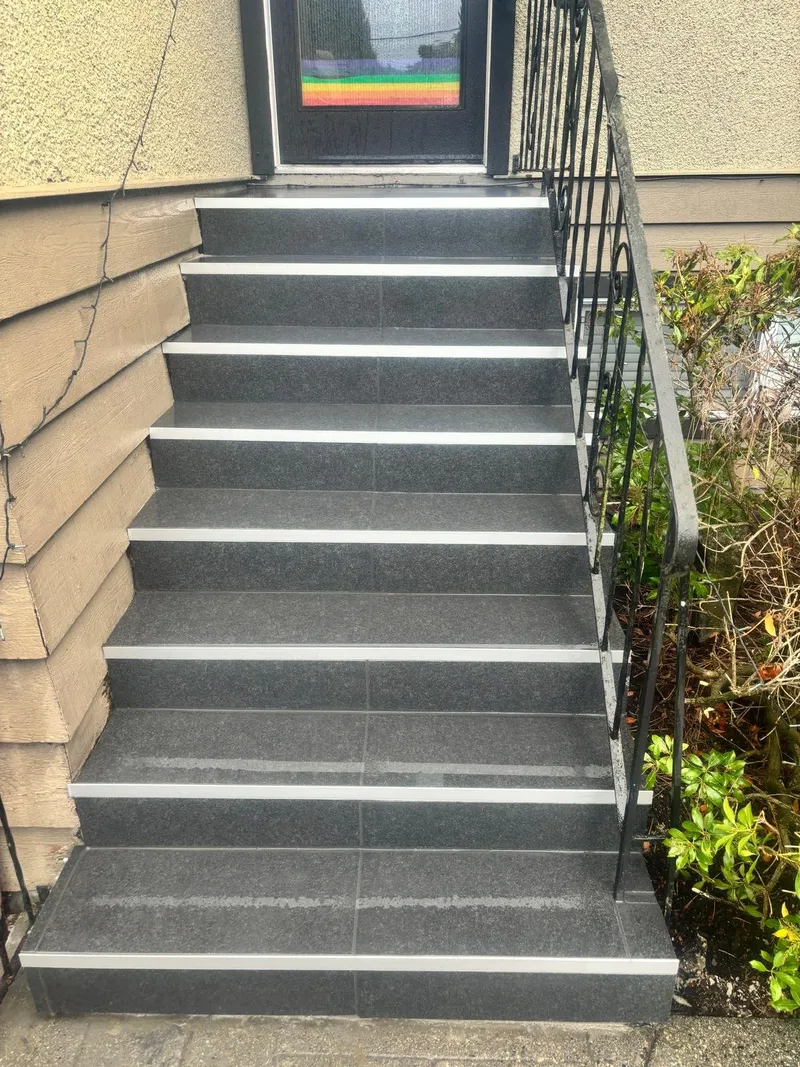 Front entry steps newly finished in dark stone with light nosing strips