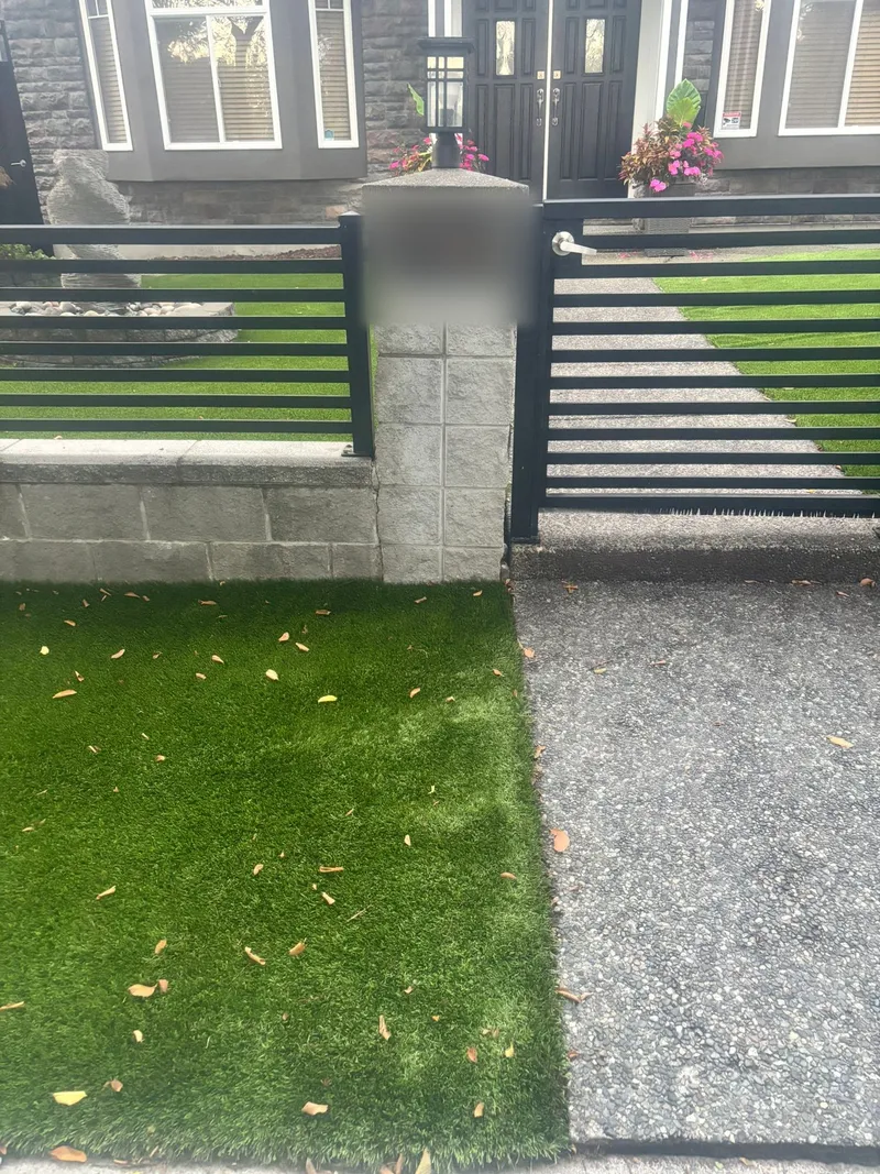 Front yard artificial turf beside a concrete walkway and slat fence